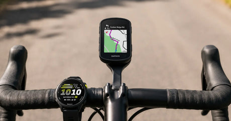 A GPS bike computer on an out-front mount ahead of the handlebar with a sports watch alongside